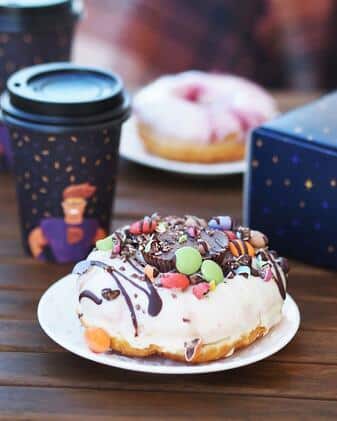 FESCHU Donuter donut s bilou polevou, čokoládou a lentilkami FESCHU Donuter donut s bilou polevou, čokoládou a lentilkami